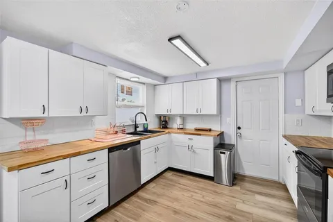 a kitchen with a sink a stove and cabinets