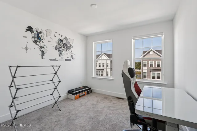 a view of a workspace with furniture and a window