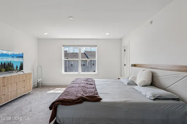 a bedroom with a large bed and a window