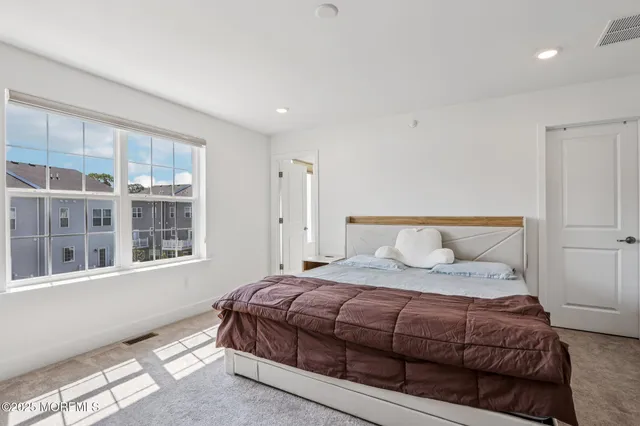 a bedroom with a bed and a large window