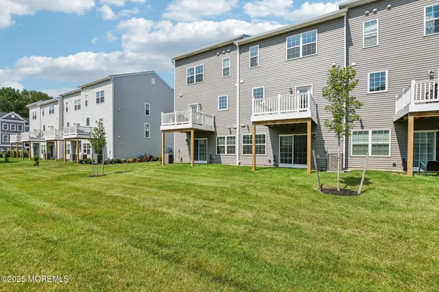 a view of an house with backyard space and balcony