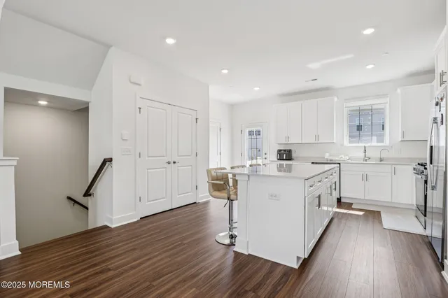 a kitchen with a sink a counter top space stainless steel appliances and cabinets