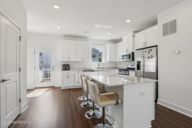 a kitchen with white cabinets and stainless steel appliances