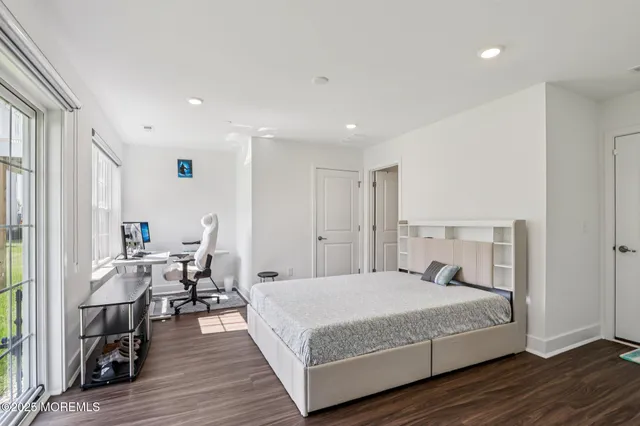 a bedroom with a large bed and wooden floor