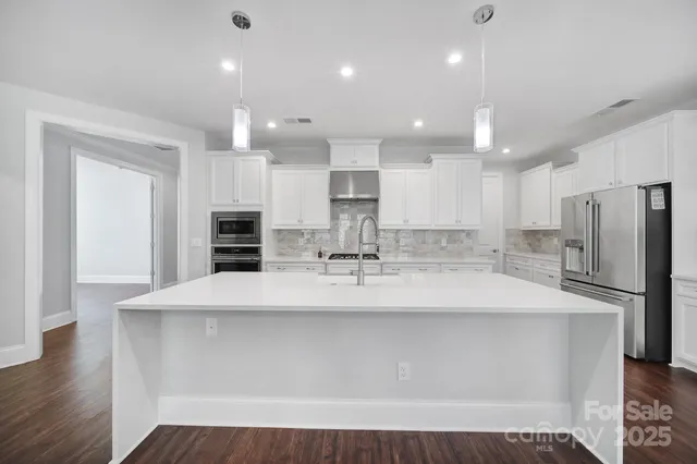 a kitchen with a sink and wooden floor