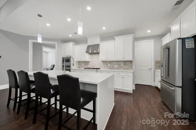 a kitchen with refrigerator cabinets dining table and chairs