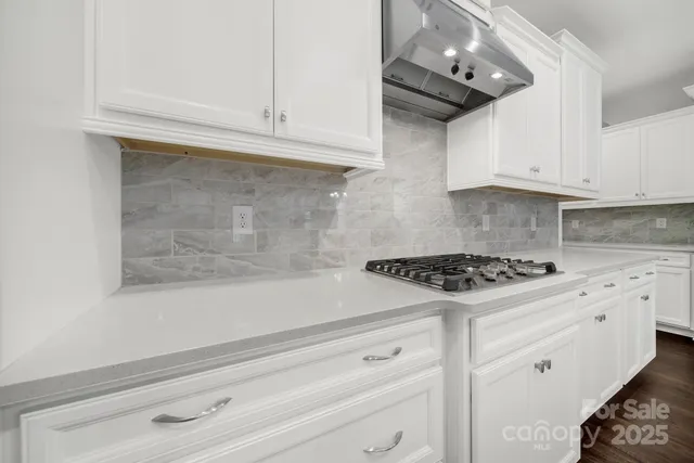a kitchen with white cabinets and appliances