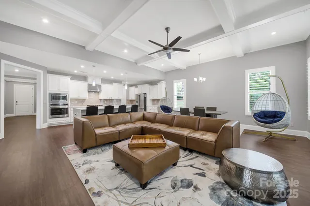 a living room with furniture and a view of kitchen