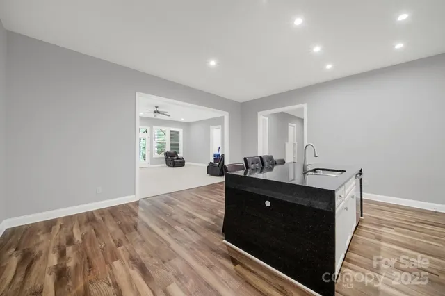 a view of a living room and bathroom with wooden floor