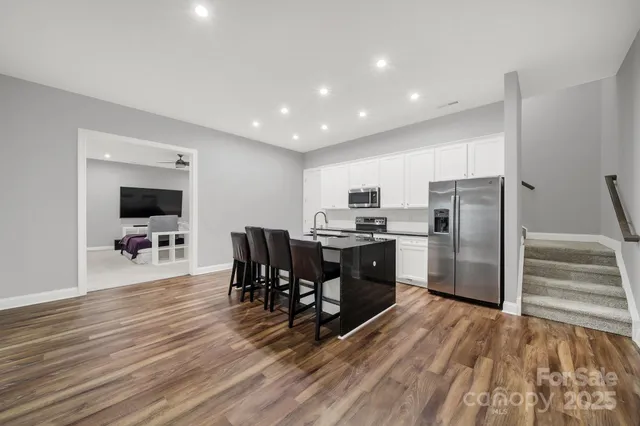 a kitchen with stainless steel appliances kitchen island granite countertop a refrigerator and a stove top oven