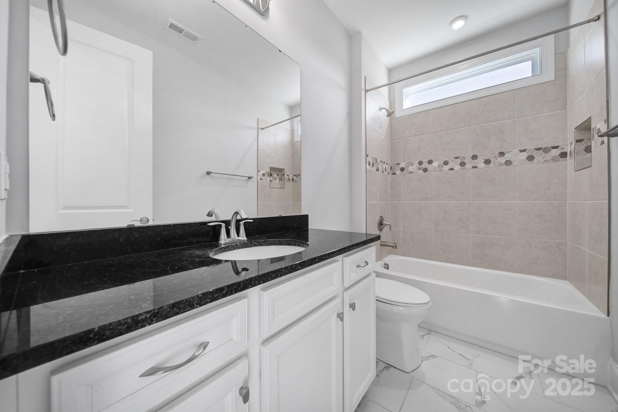 3509 Aqua Point Drive York, SC 29745 - Photo 3 of 48 a bathroom with a granite countertop sink a toilet a mirror and bathtub