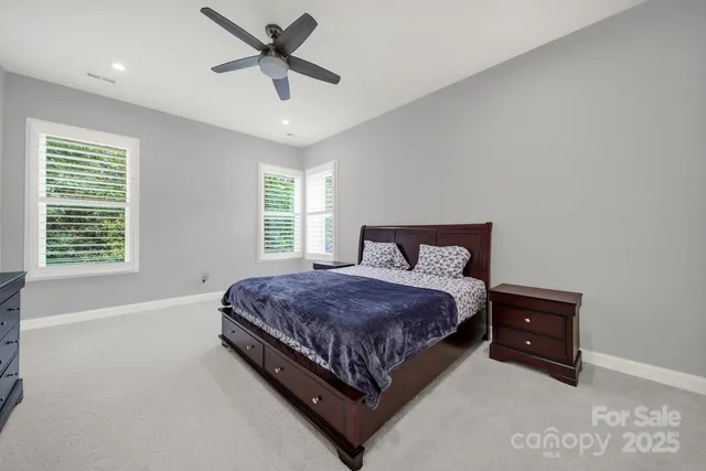 a spacious bedroom with a bed and a ceiling fan