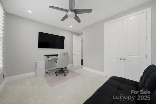 a view of a livingroom with workspace and a flat screen tv