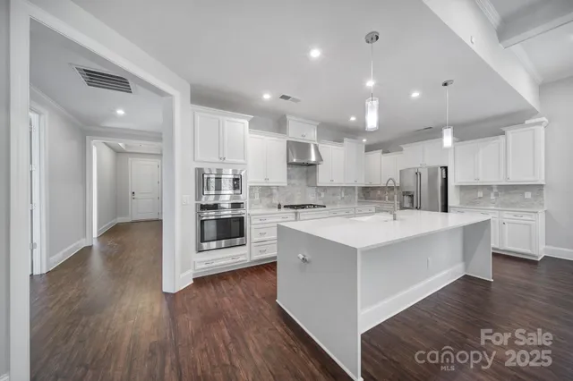 a kitchen with granite countertop a refrigerator and a stove top oven