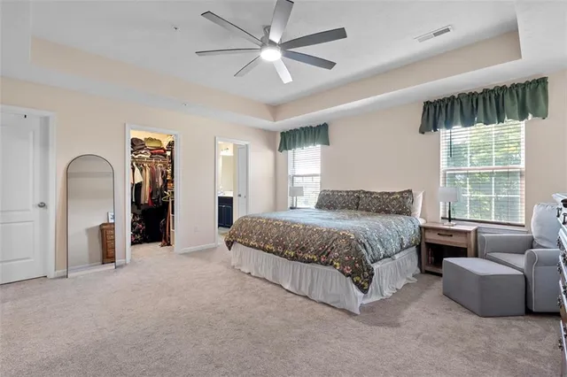 a spacious bedroom with a bed a couch and a large window