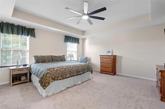 a spacious bedroom with a bed and a ceiling fan