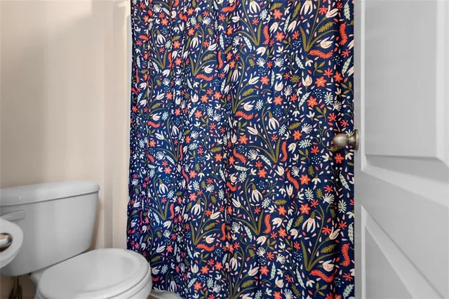 a white toilet sitting next to a shower curtain