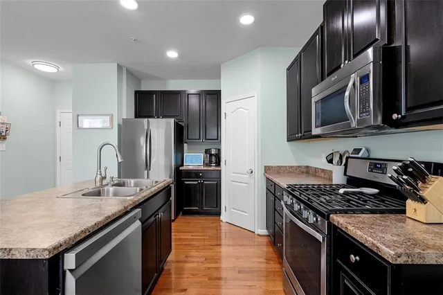 a kitchen with kitchen island granite countertop stainless steel appliances and wooden cabinets