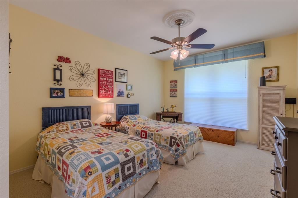 166 County Road 2112 Pittsburg, TX 75686 - Photo 17 of 40 a bedroom with a bed and a chandelier