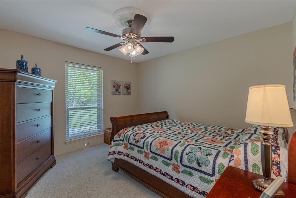 166 County Road 2112 Pittsburg, TX 75686 - Photo 18 of 40 a bedroom with a bed and a chandelier