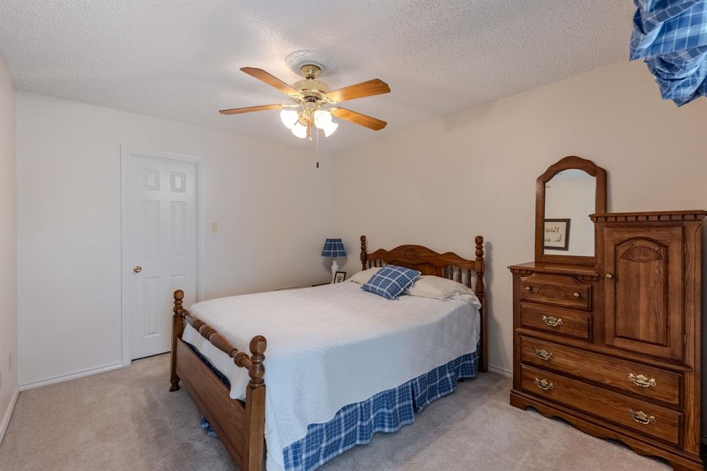 166 County Road 2112 Pittsburg, TX 75686 - Photo 21 of 40 a bedroom with a bed and a chandelier