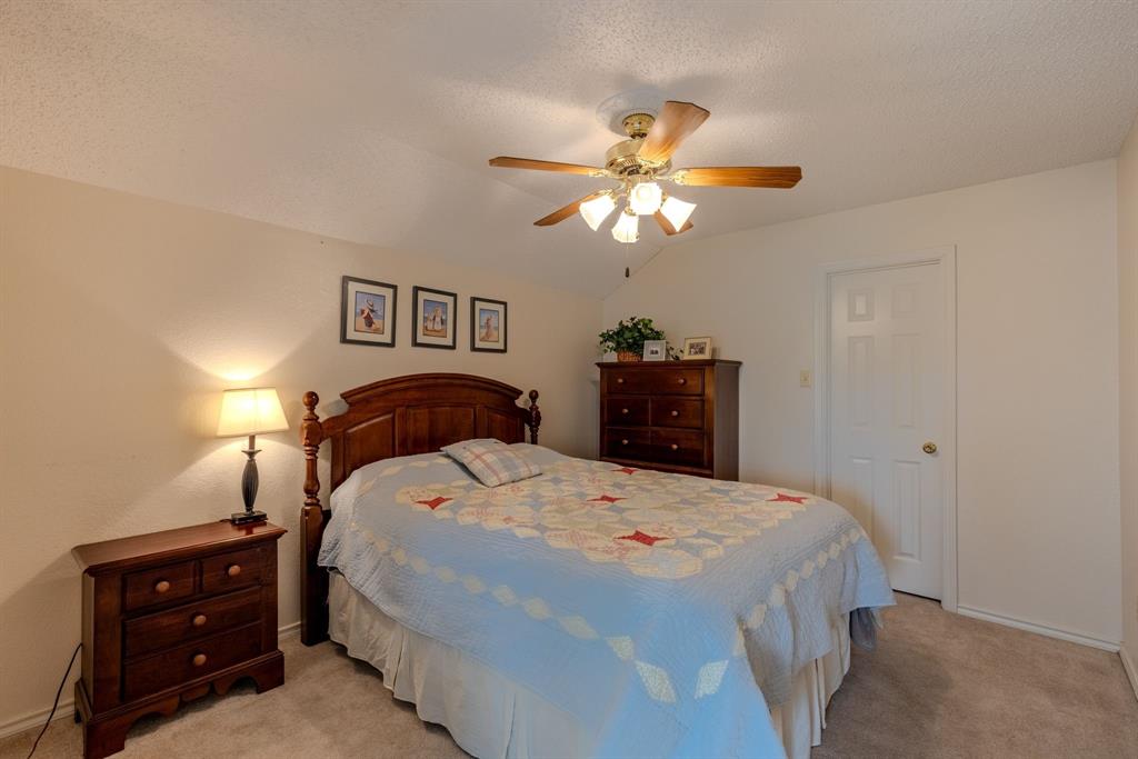 166 County Road 2112 Pittsburg, TX 75686 - Photo 22 of 40 a bedroom with a bed and a chandelier
