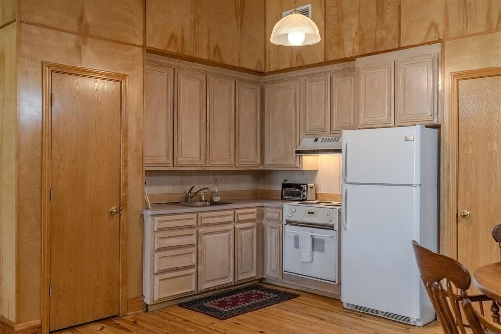 166 County Road 2112 Pittsburg, TX 75686 - Photo 30 of 40 a kitchen with a sink a refrigerator and cabinets