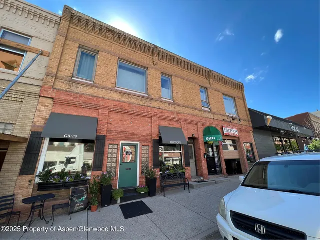 a front view of a building with outdoor seating