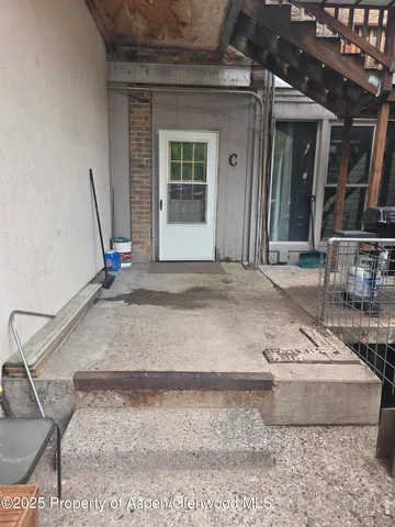 a view of a hall with a floor to ceiling window and potted plants
