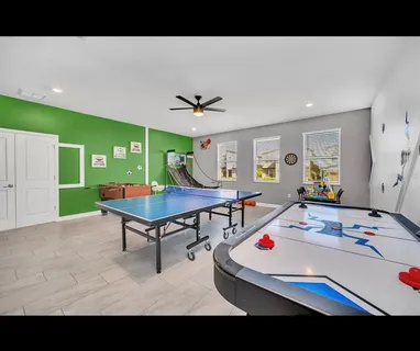 a living room with furniture and a pool table