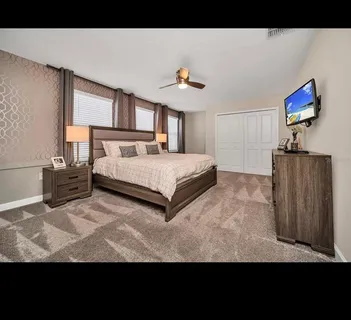 a spacious bedroom with a bed and a flat screen tv