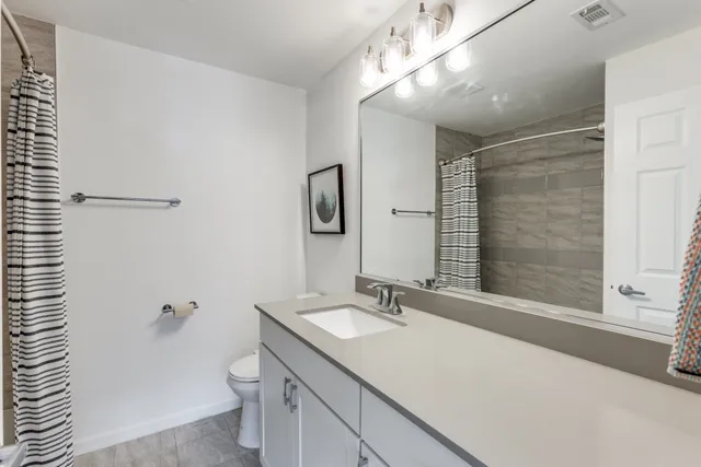 a bathroom with a sink double vanity granite tub and shower