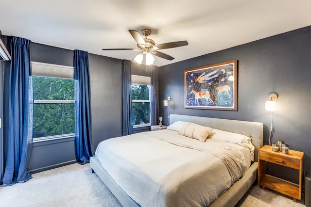 a bedroom with a large bed and a chandelier