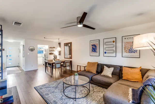 a living room with furniture a dining table and a chandelier