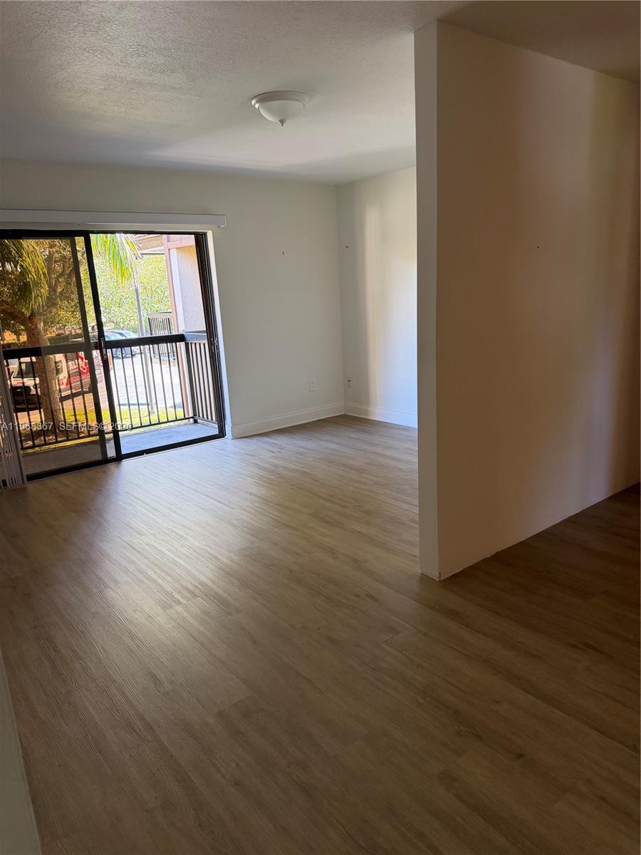 7925 Southwest 86th Street, Unit 923 Miami, FL 33143 - Photo 3 of 10 wooden floor in an empty room with a window