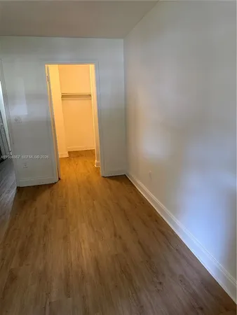 an empty room with wooden floor and a window