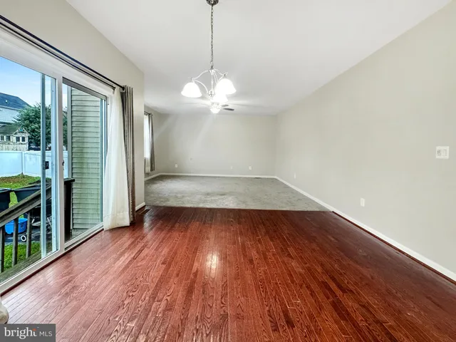 a dining room with furniture a chandelier and wooden floor