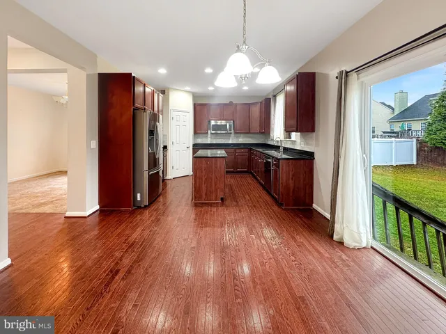 a kitchen with wooden cabinets stainless steel appliances a sink and a center island