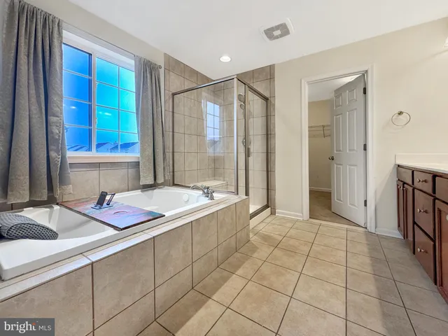 a spacious bathroom with a double vanity sink mirror and shower