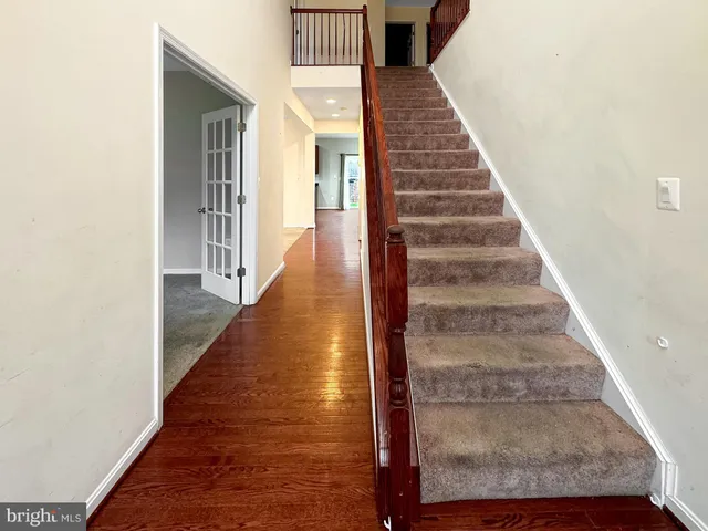 a view of staircase with wooden floor and white walls