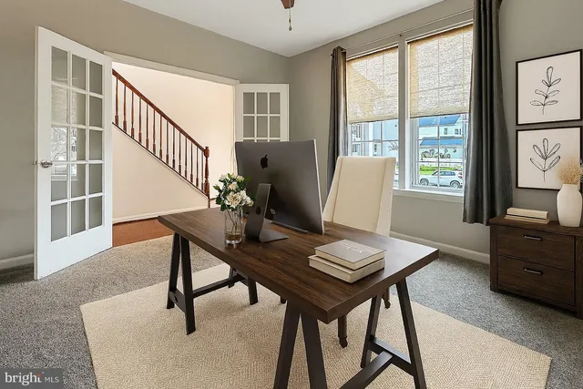 a view of a workspace with furniture and a window