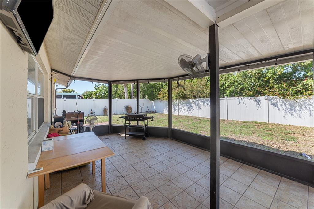 8715 Huntsman Lane Port Richey, FL 34668 - Photo 47 of 54 a view of a patio with table and chairs under an umbrella with a small yard