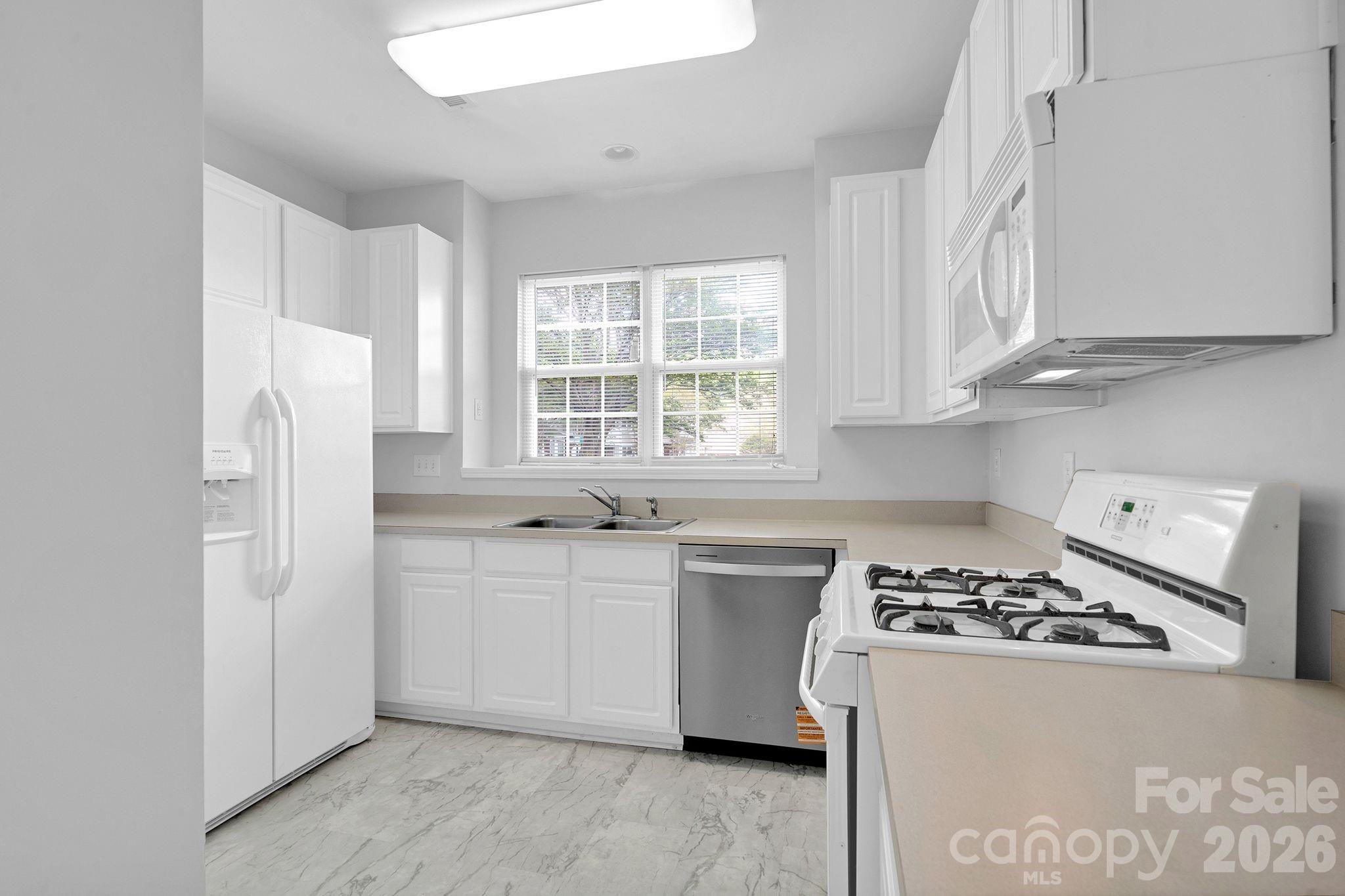 4966 Sunset Ridge Court Charlotte, NC 28269 - Photo 12 of 42 a kitchen with stainless steel appliances a sink a stove and a refrigerator