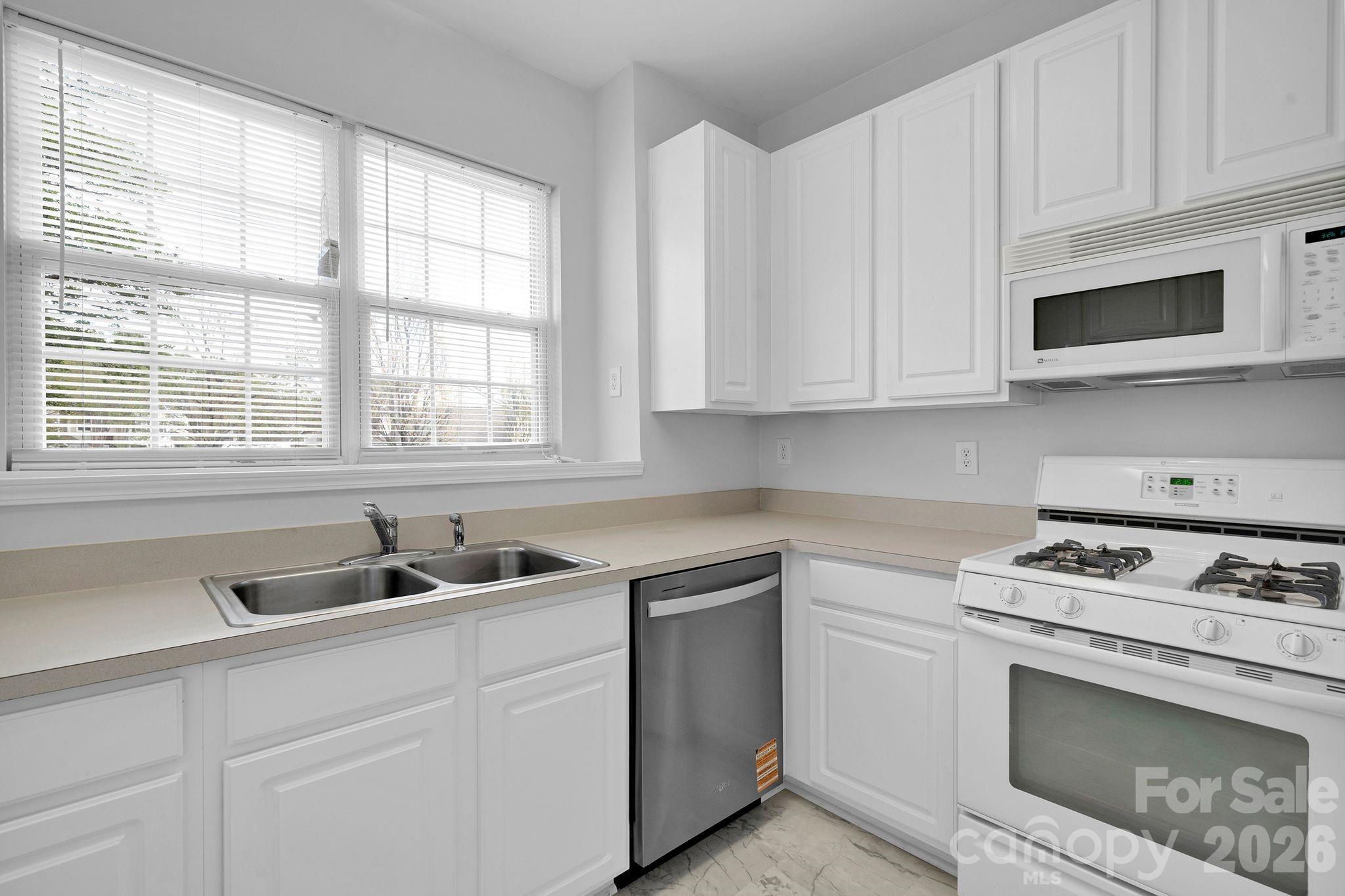 4966 Sunset Ridge Court Charlotte, NC 28269 - Photo 13 of 42 a kitchen with white cabinets and a stove top oven
