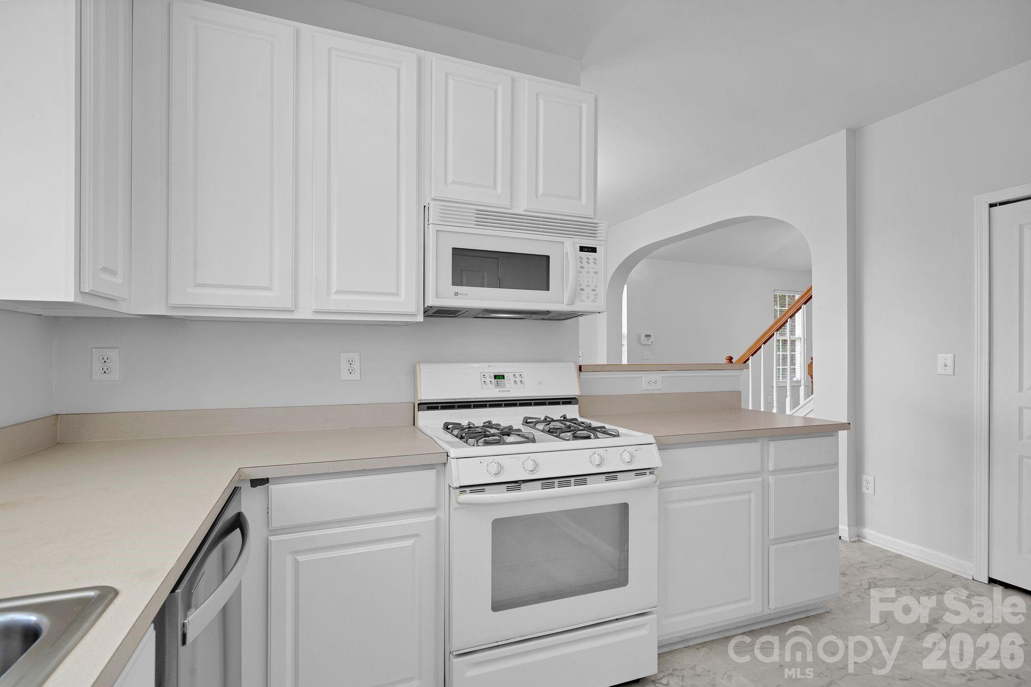 4966 Sunset Ridge Court Charlotte, NC 28269 - Photo 14 of 42 a kitchen with white cabinets and white appliances