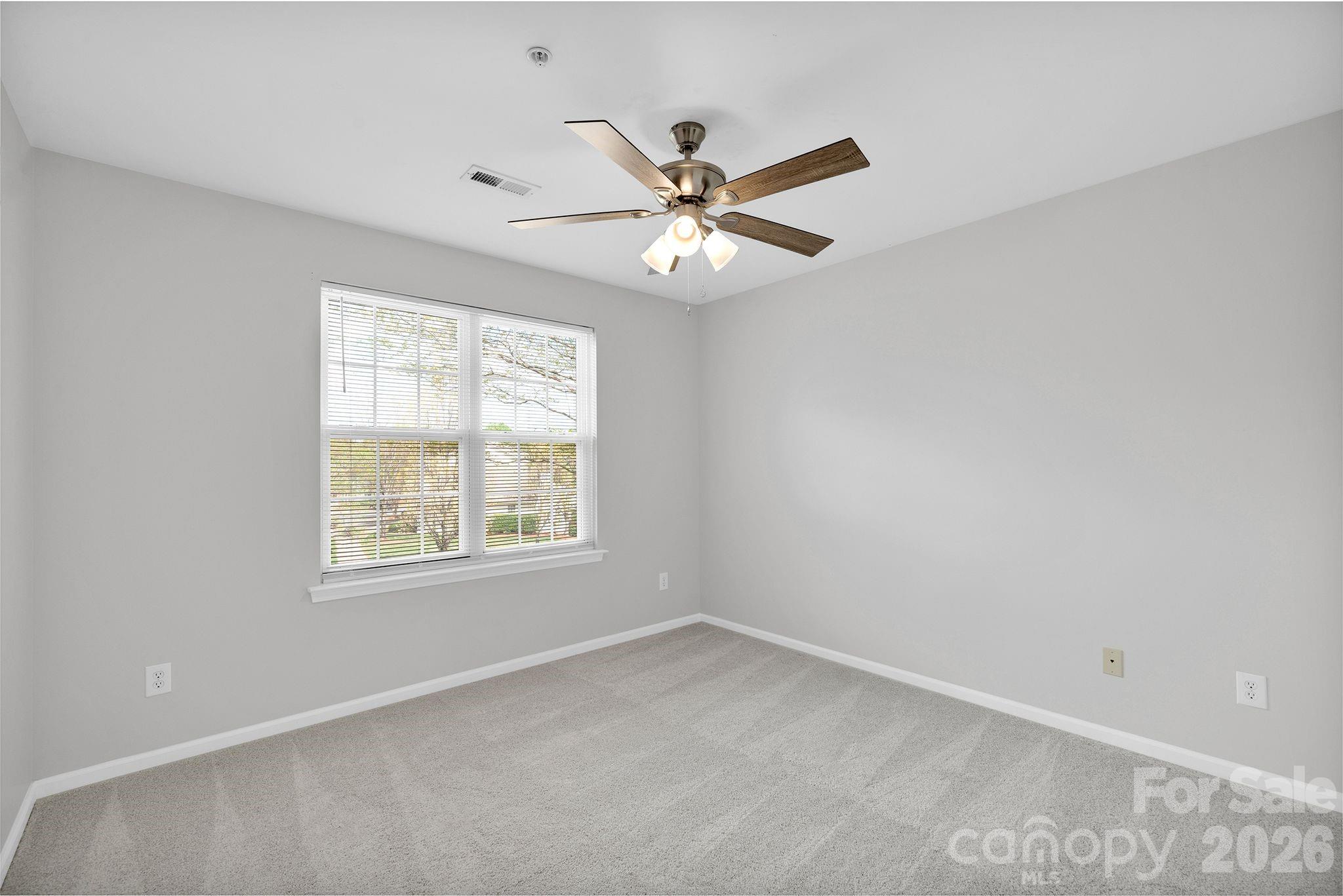 4966 Sunset Ridge Court Charlotte, NC 28269 - Photo 24 of 42 an empty room with a window and a fan