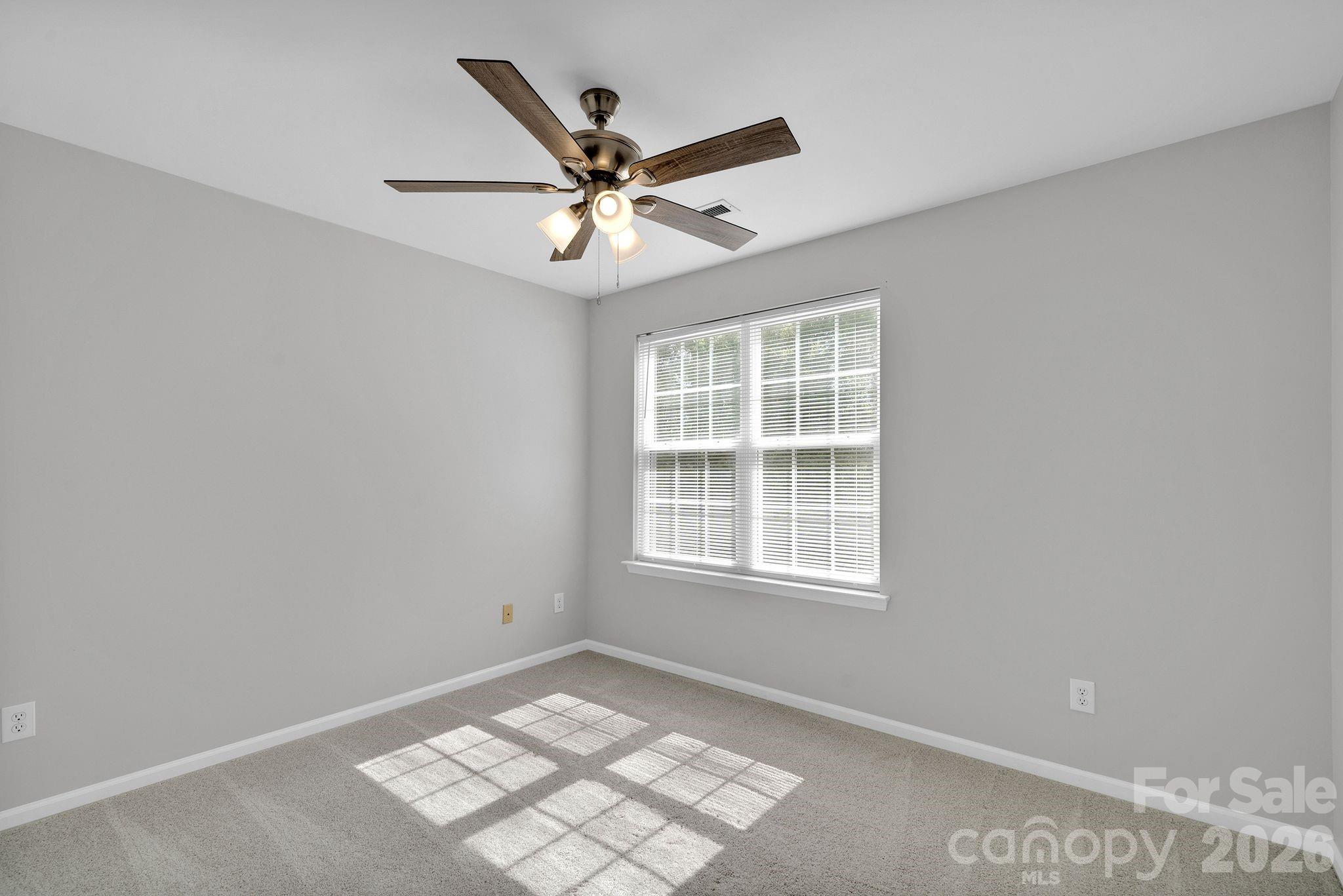 4966 Sunset Ridge Court Charlotte, NC 28269 - Photo 27 of 42 an empty room with windows and fan