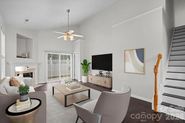 an empty room with windows fireplace and wooden floor