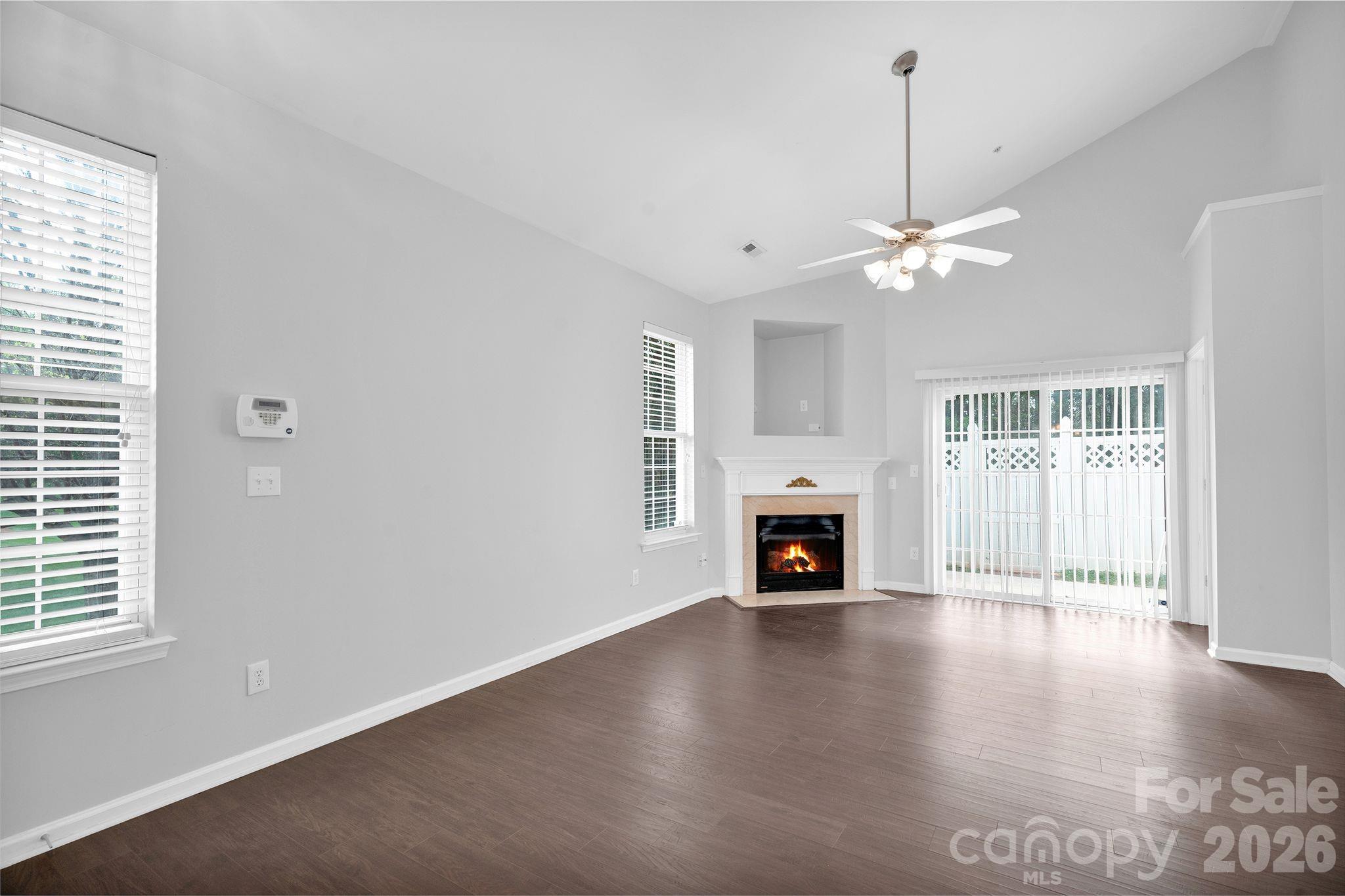 4966 Sunset Ridge Court Charlotte, NC 28269 - Photo 6 of 42 an empty room with windows fireplace and wooden floor