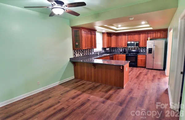 a view of a room with wooden floor and chandelier